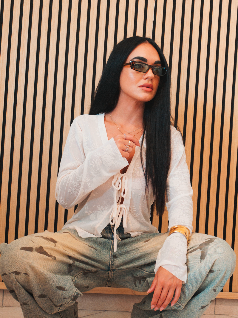Blusa bianca semitrasparente con ricami floreali e fiocchi